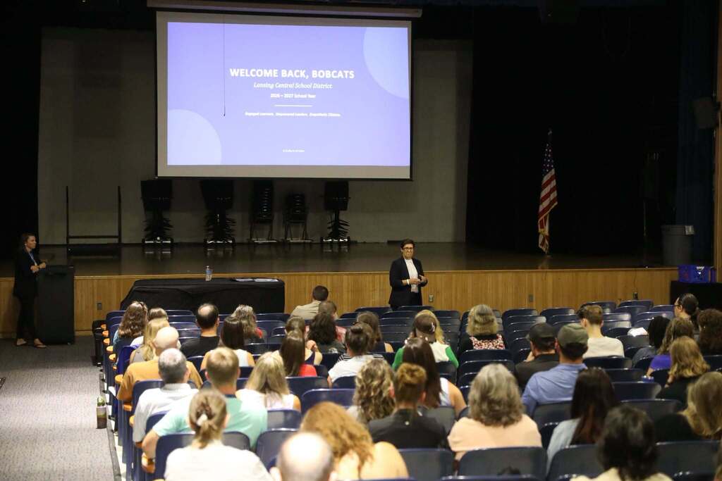 staff gathered in auditorium listening to a speech