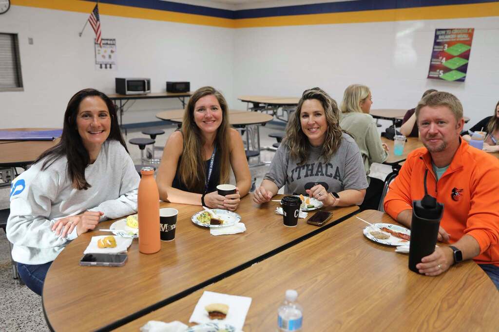 four staff members at a table smiling at camera