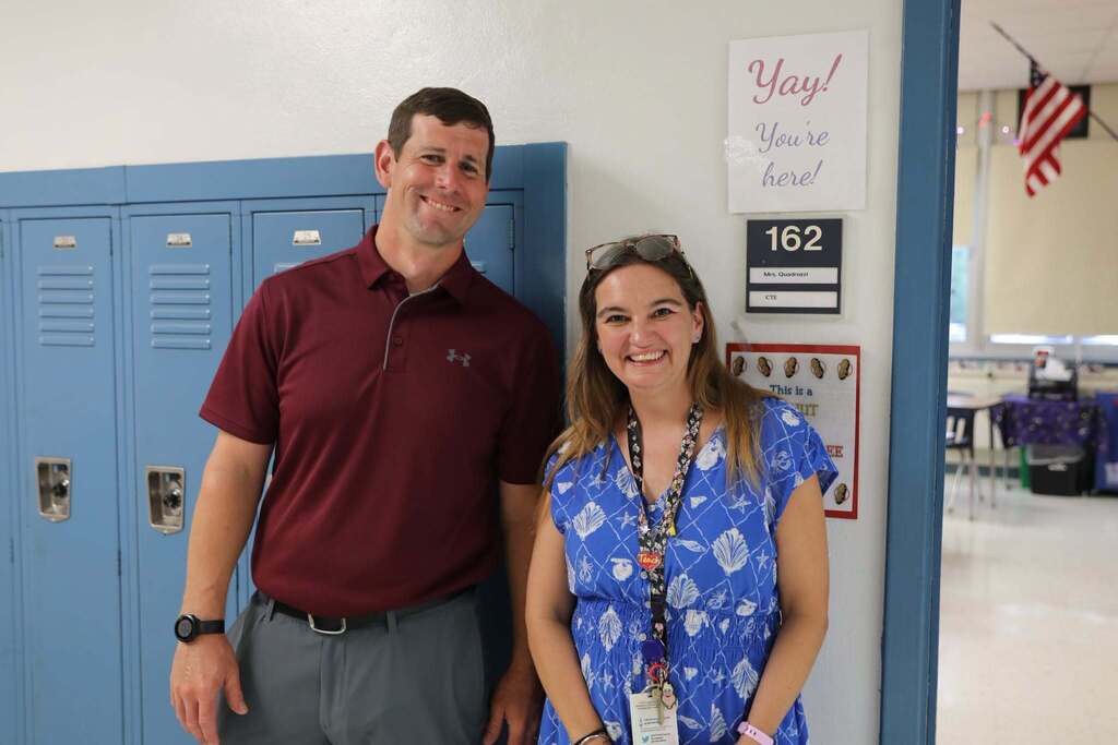 two staff members smiling at camera
