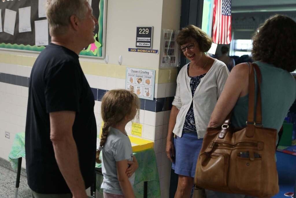 a teacher greeting a family at their door