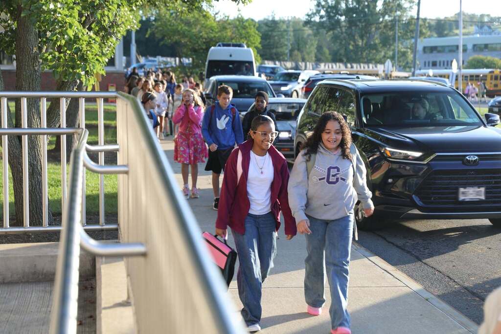 a line of students walking up to school