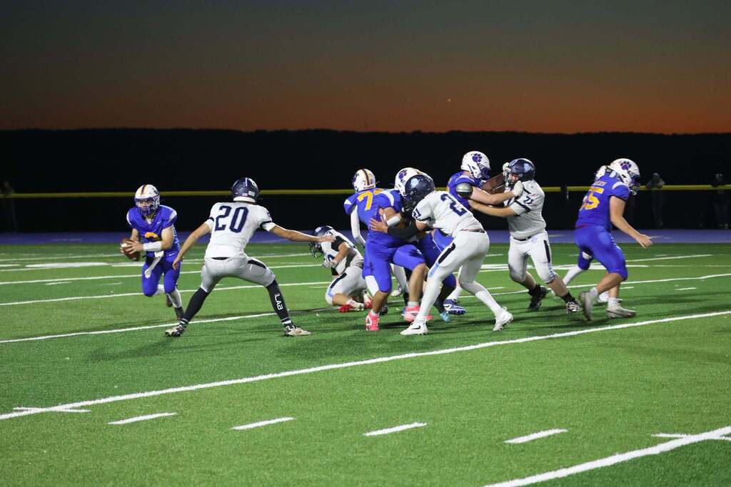 a wide of a football game with the players all starting a play