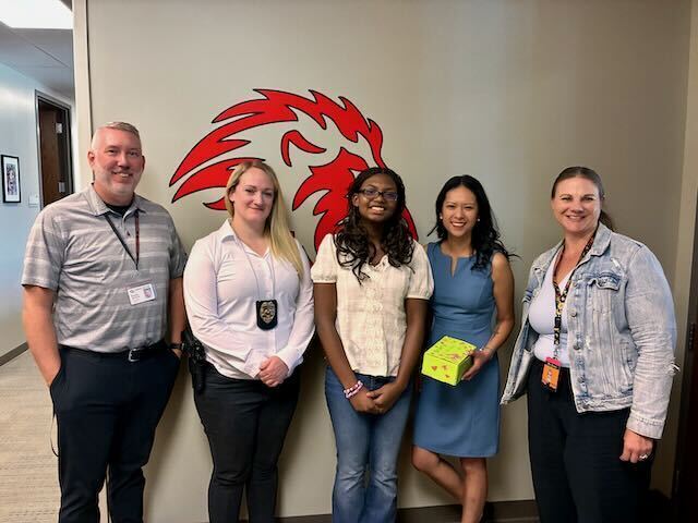 8th Grade Student posing with principal, counselor, and children's advocacy rep 