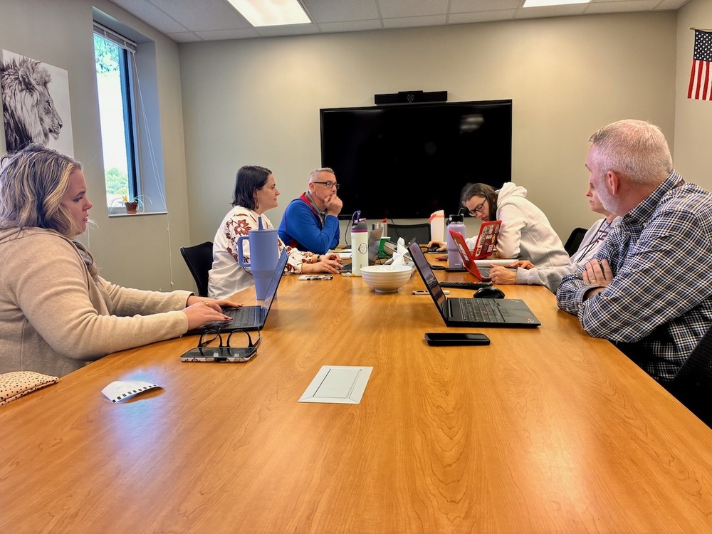 Lansing USD 469 is proud to continue its partnership with the University of Kansas’ Center for Reimagining Education (CRE), entering the second year of an innovative project that’s redefining what learning can look like in the age of artificial intelligence. After a successful first year that earned statewide recognition and a $10,000 grant to expand the initiative, Lansing Middle School’s sixth-grade science team—Principal Brooks Jenkins and teachers Alisha Holyfield, Amanda Thomas, and Josh Yoakam—kicked off Year Two with renewed energy and new goals for growth. The team recently met with Maggie Mosier, KU’s “AI guru,” and Megan Turpin, KU’s instructional coach, to reflect on their successes and begin mapping out next steps. Their meeting focused on how to deepen the integration of AI tools into classroom instruction while maintaining the heart of what makes learning meaningful: curiosity, creativity, and student ownership. “We learned so much in the first year about how students respond when they’re given real choice and powerful tools,” said Amanda Thomas. “Now we want to build on that momentum and help even more students see themselves as thinkers, creators, and problem solvers.” During the session, the group discussed expanding their project-based approach into additional class periods and grade levels, developing model lessons other teachers can adapt, and creating practical resources for staff on using AI safely and effectively. Maggie Mosier guided the team in exploring the evolving role of AI in education, while Megan Turpin provided hands-on coaching and support to help teachers design classroom experiences that balance innovation with intentional teaching. Principal Brooks Jenkins shared that the team’s goal for this year is sustainability: “We want to move from experimenting with AI to embedding it as a natural, purposeful part of instruction. The more our teachers grow, the more our students benefit.” As the partnership enters its second year, Lansing continues to stand out as a leader in reimagining education—not just with technology, but with a clear focus on empowering students and teachers alike.