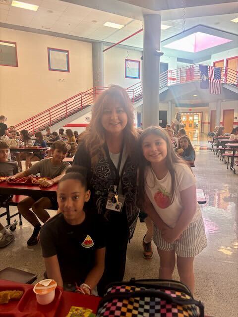 Two students with Principal in cafeteria