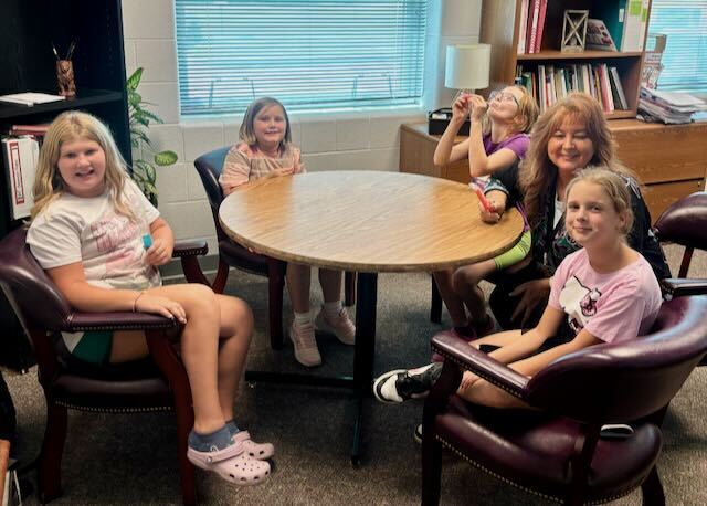 Students sitting with their principal at a table