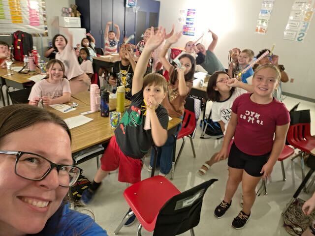 Students celebrating the start of school with their teacher in the classroom