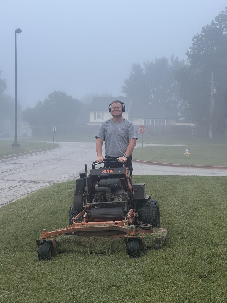 Maintenance Crew mowing grass early in the morning