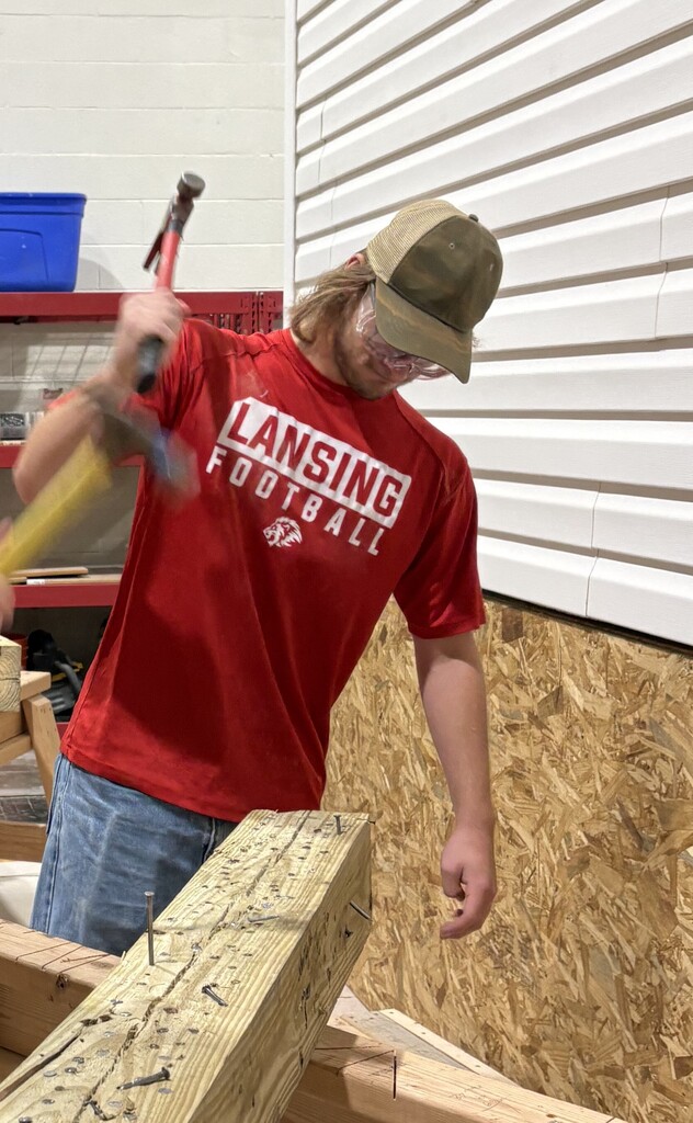 High School Construction Student at KCKCC driving nails into wood