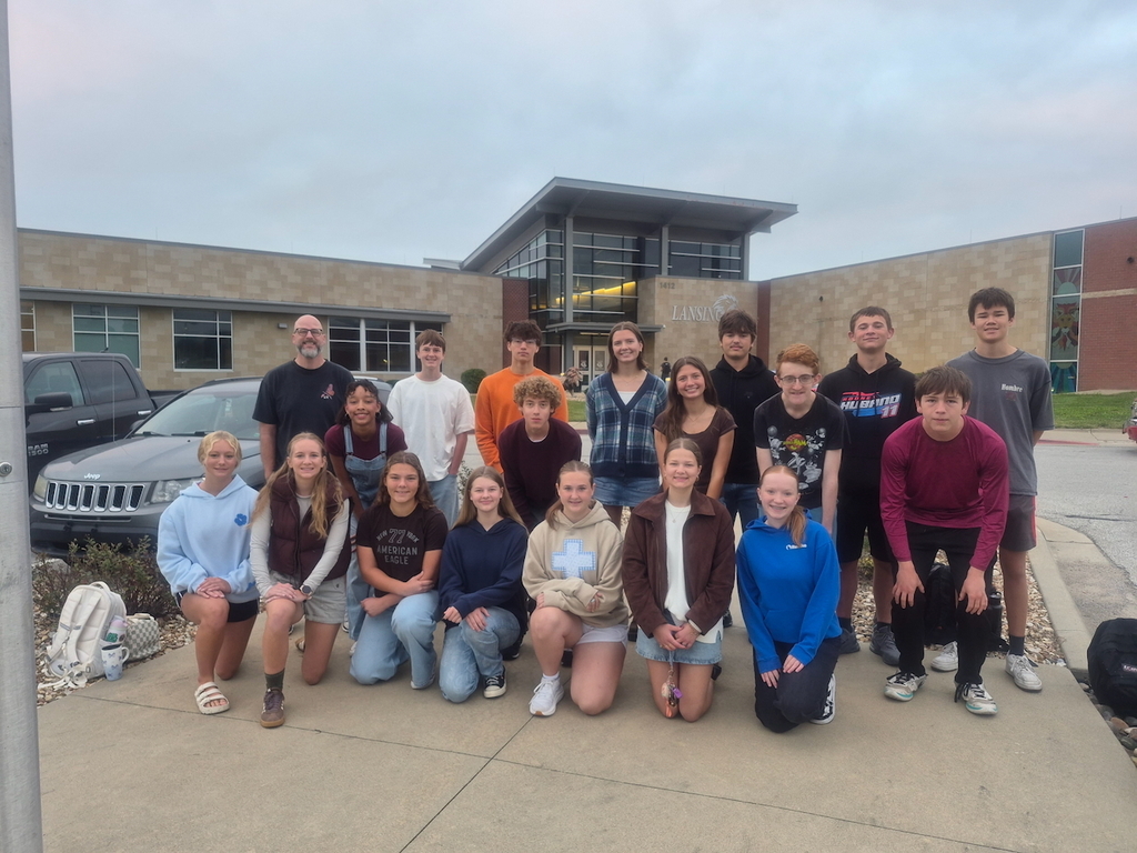 Students smiling in front of high school