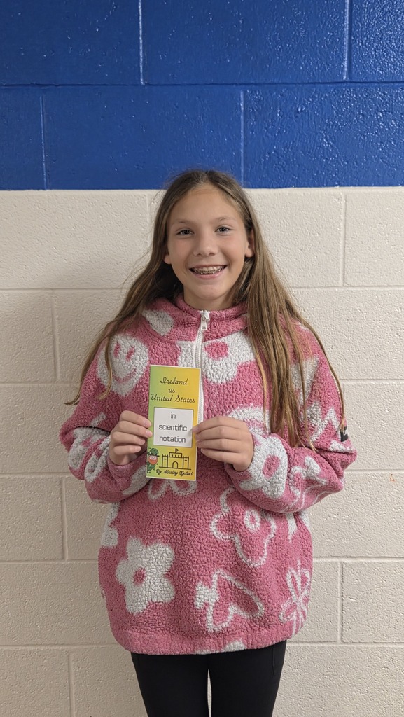 8th Grade student holding travel brochure for class project