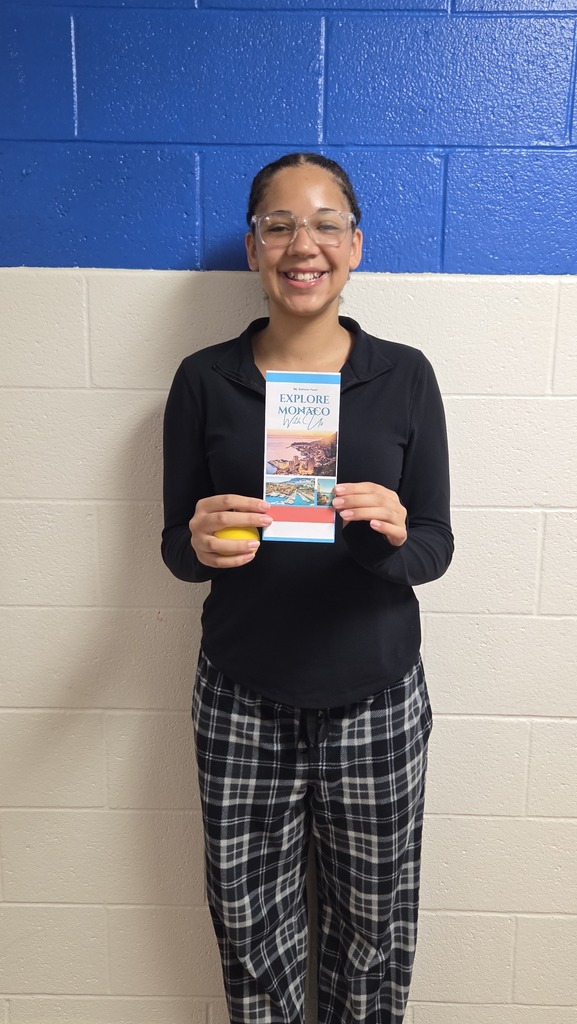 8th Grade student holding travel brochure for class project