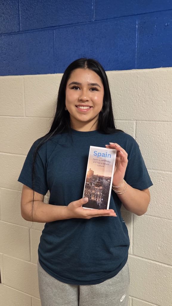 8th Grade student holding travel brochure for class project