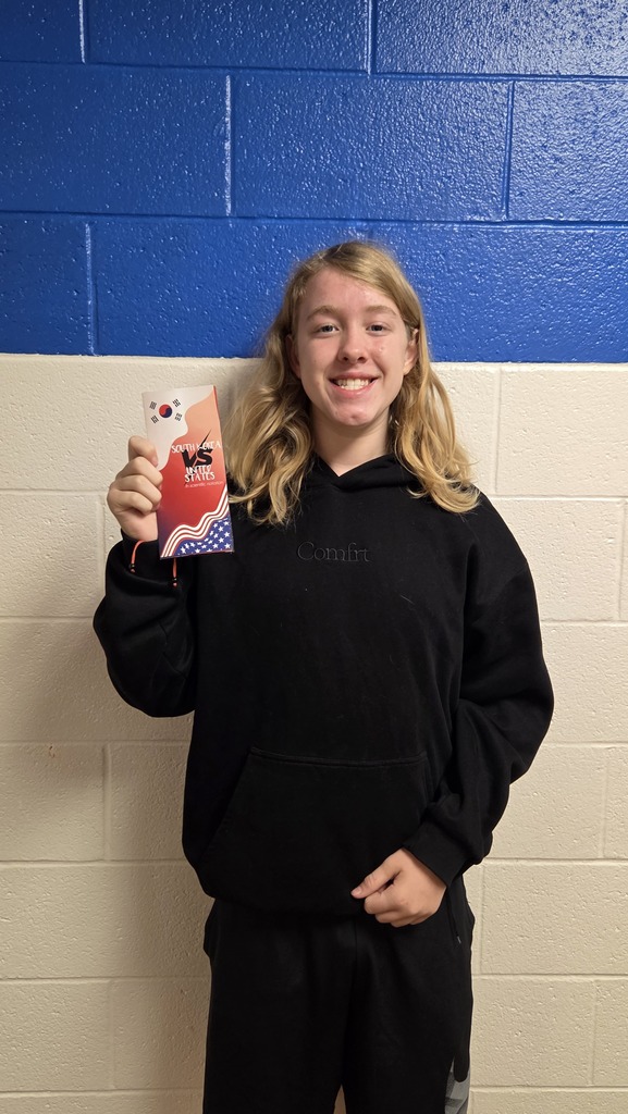 8th Grade student holding travel brochure for class project