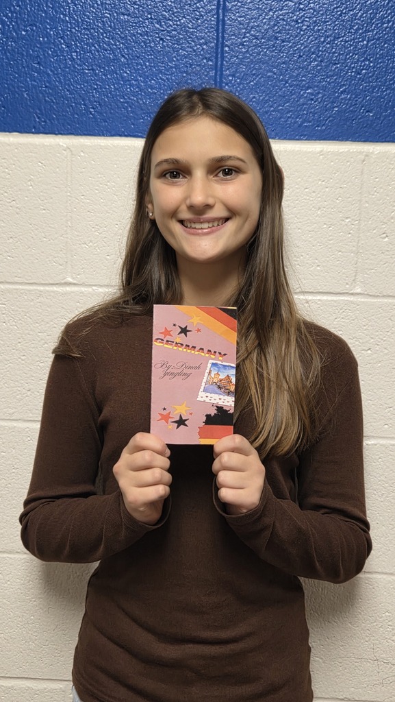 8th Grade student holding travel brochure for class project