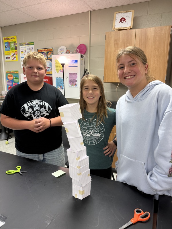 6th grade science students posing with their tower experiment