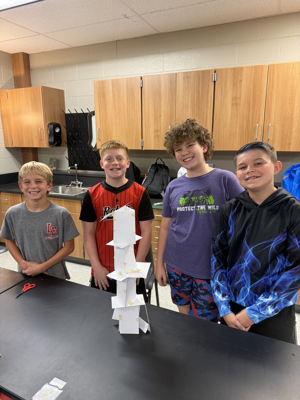 6th grade science students posing with their tower experiment