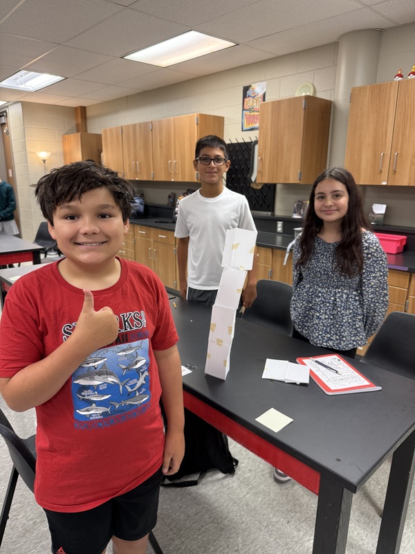 6th grade science students posing with their tower experiment