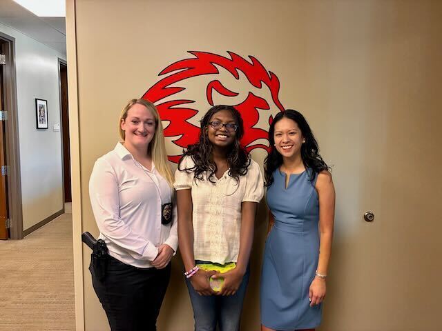 8th Grade Student posing with principal, counselor, and children's advocacy rep