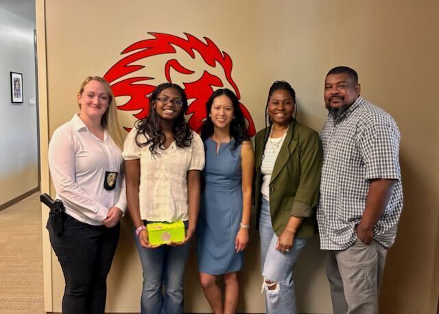 8th Grade Student posing with principal, counselor, and children's advocacy rep
