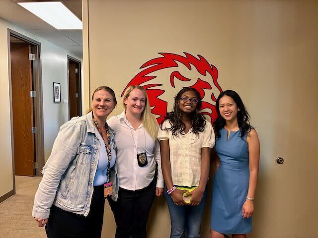 8th Grade Student posing with principal, counselor, and children's advocacy rep