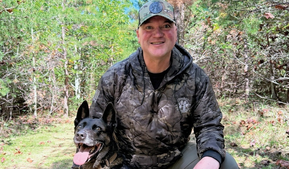 Jason Johnson outdoors with a police dog