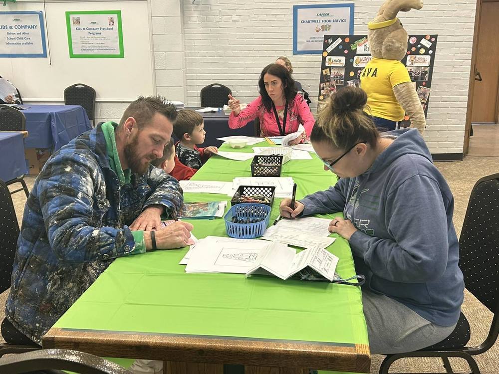 Image of parents filling out forms at the 2024 Kindergarten Round-Up