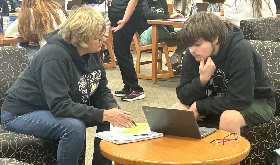 High school counselor working with a student on college plans