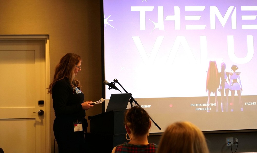 LVP teacher presenting at a podium with screen in background