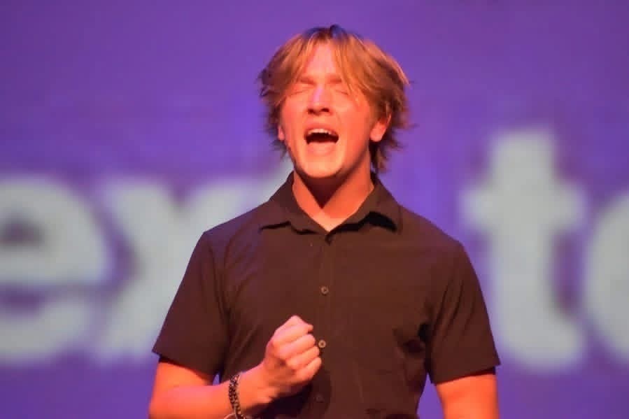 Lapeer student Griffyn Fenner singing a song on stage