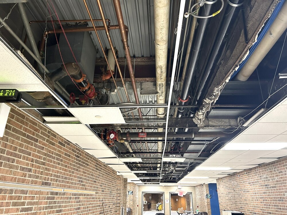 Photo of uncovered ceiling at Lapeer High School showing new water main lines