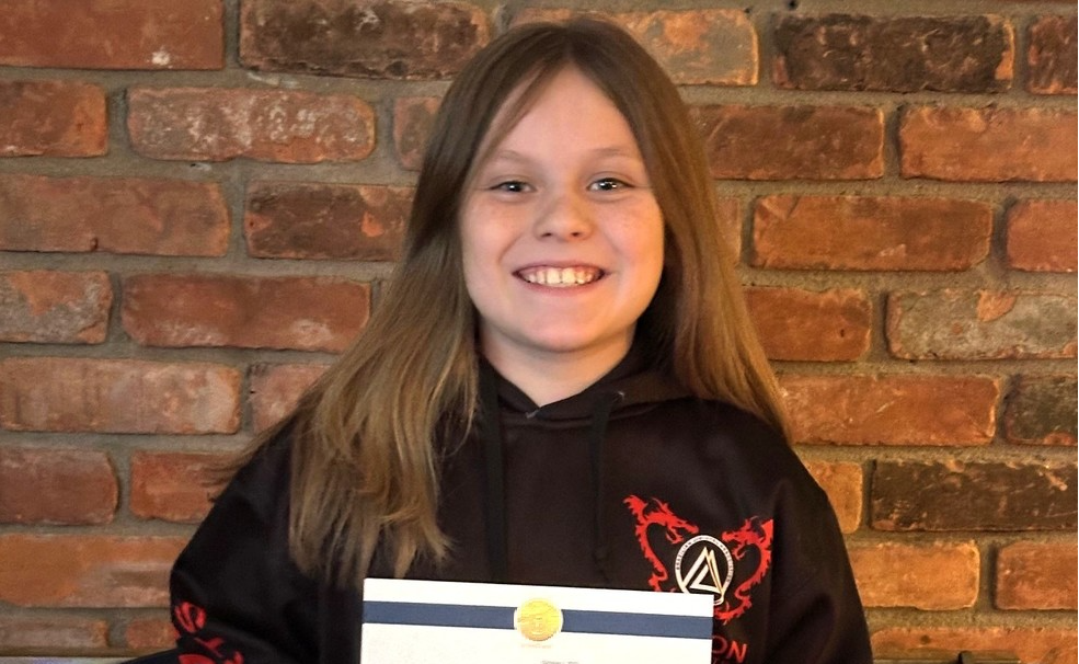 Jamie Aeder holding a letter announcing his selection to STEM camp
