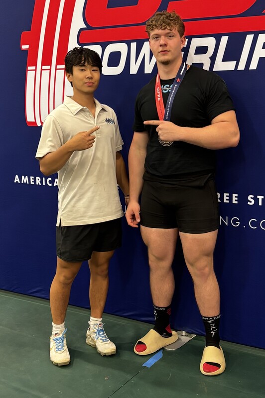 Zane Sanchez posing with a friend at the world powerlifting championships in Florida