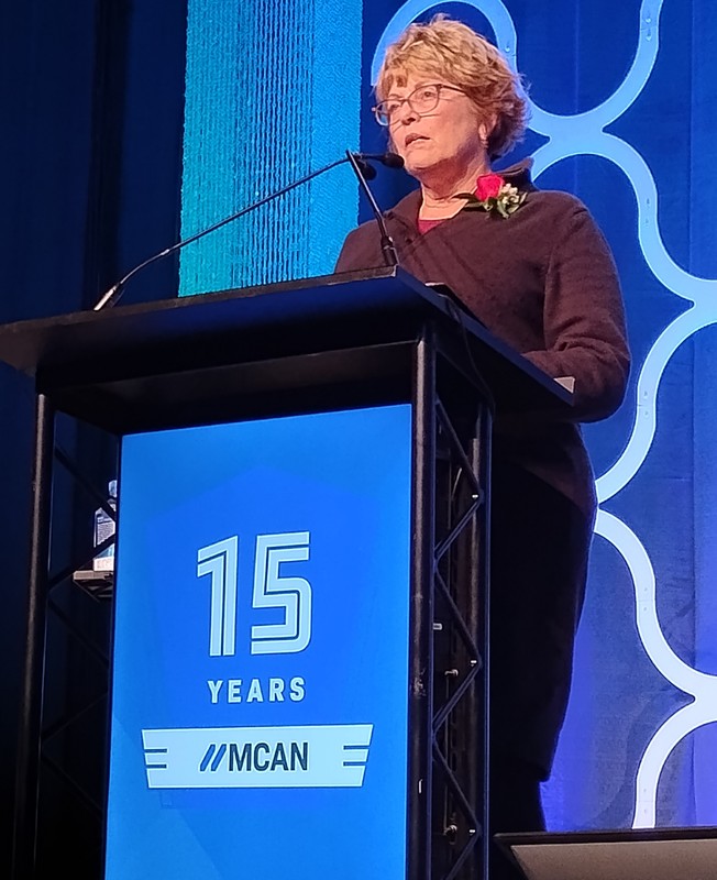 Julie Pecore speaking at the podium