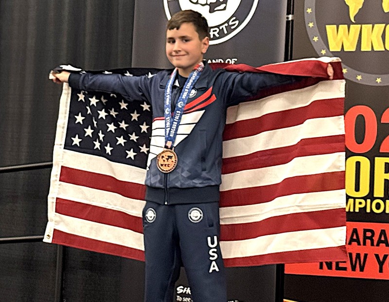 Brody Kosemba with an American flag at a karate competition