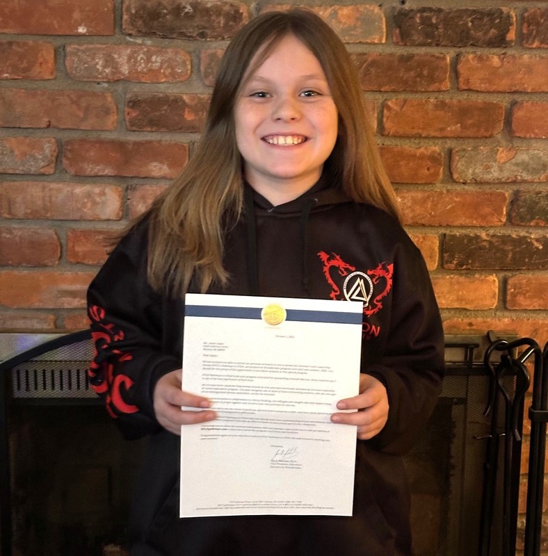Jamie Aeder holding a letter announcing his selection to STEM camp
