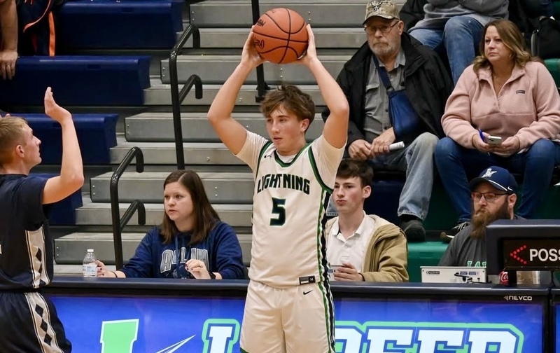 Lapeer basketball player Will Fisher with his milestone banner