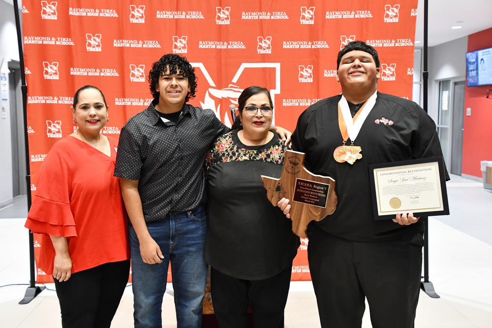 state powerlifter mhs junior javi posing with his family for a group photo