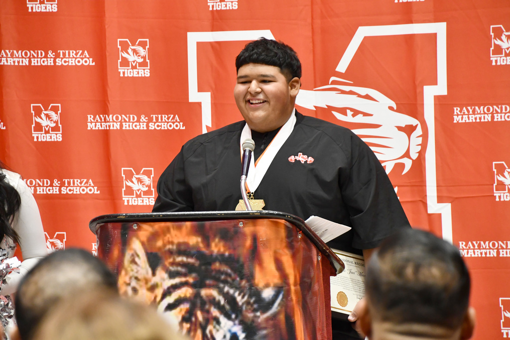 State powerlifter Javi talking at the podium