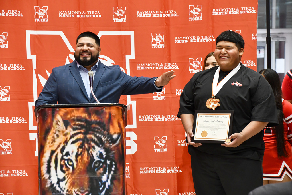 Martin High School coarch mark duron and javi talking at the podium
