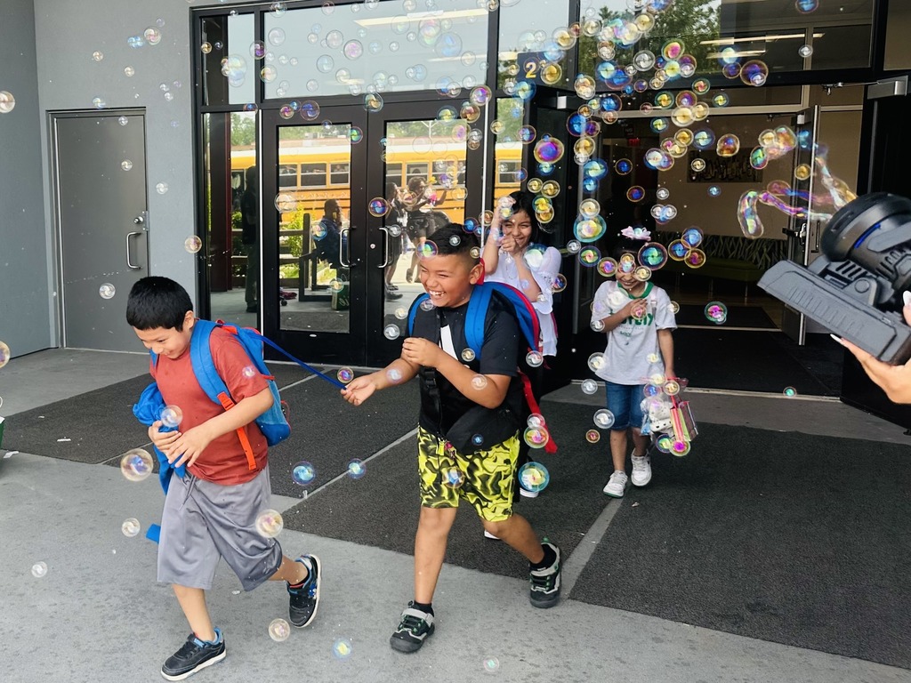 kids smiling walking out of building