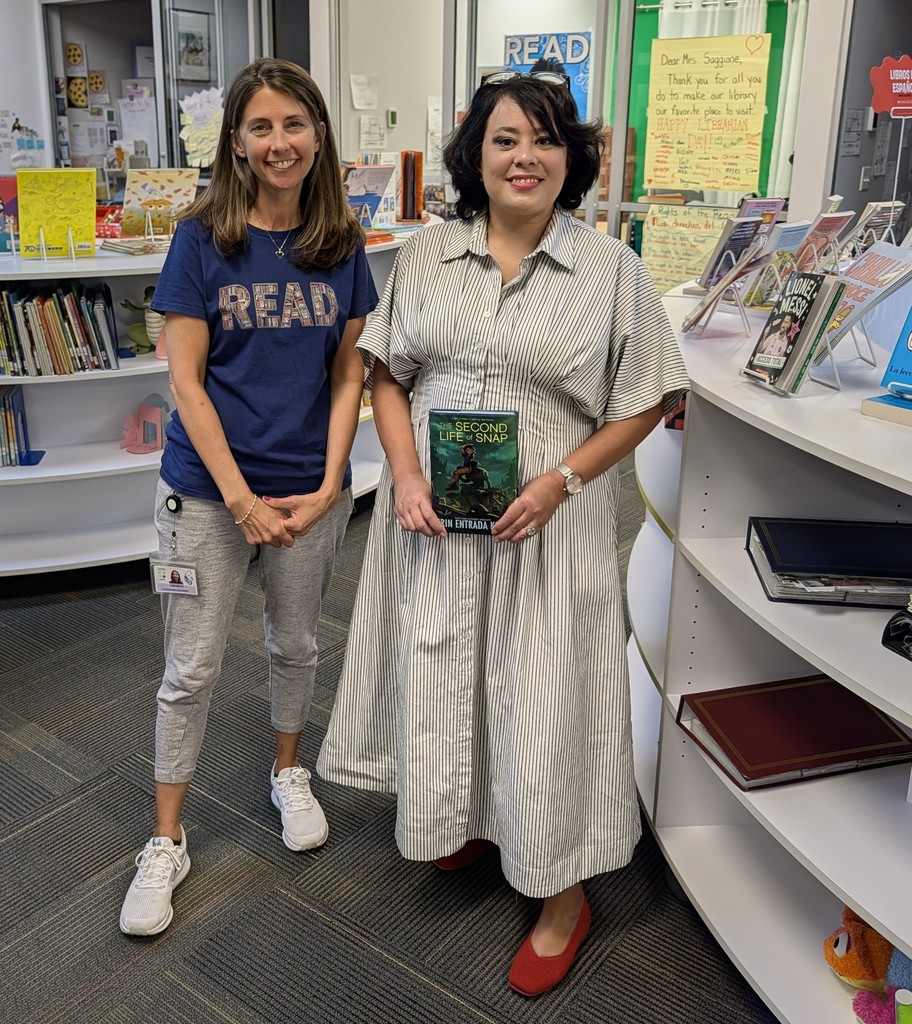 Author Erin Entrada Kelly posing with school librarian Mrs. Saggione and her new book.