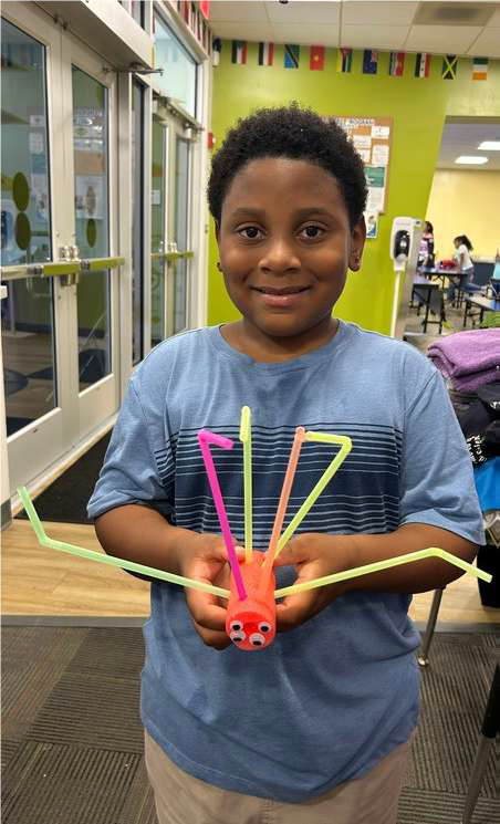 boy with spider made of straws