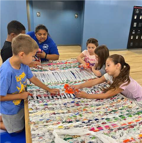 6 kids weaving with plastic and ribbons 