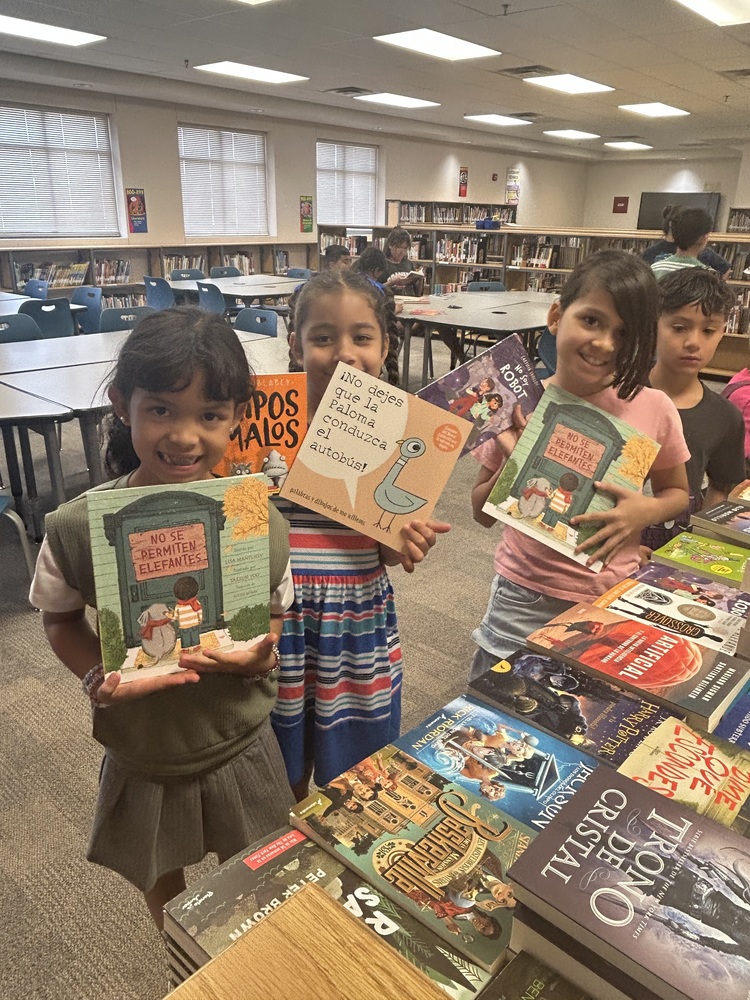 students in library holding books