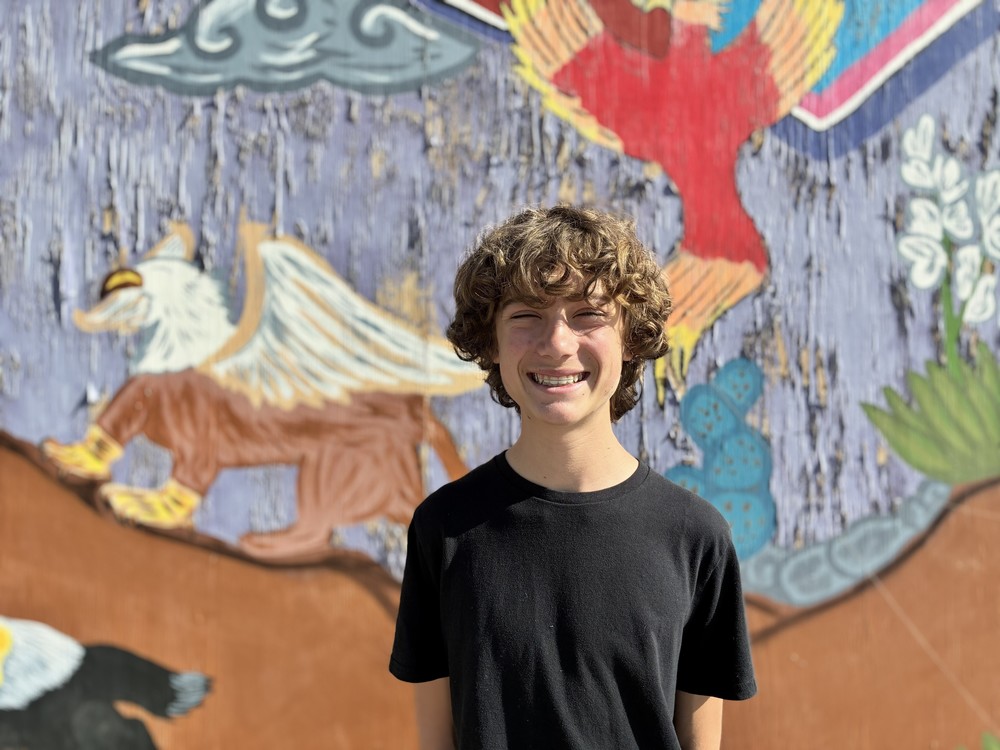 photo of student standing against a colorful wall