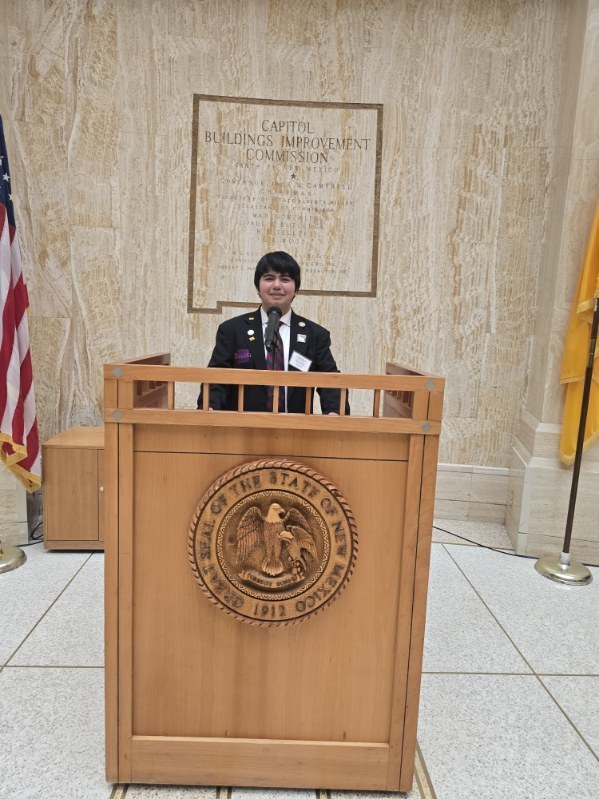 student posing behind a podium