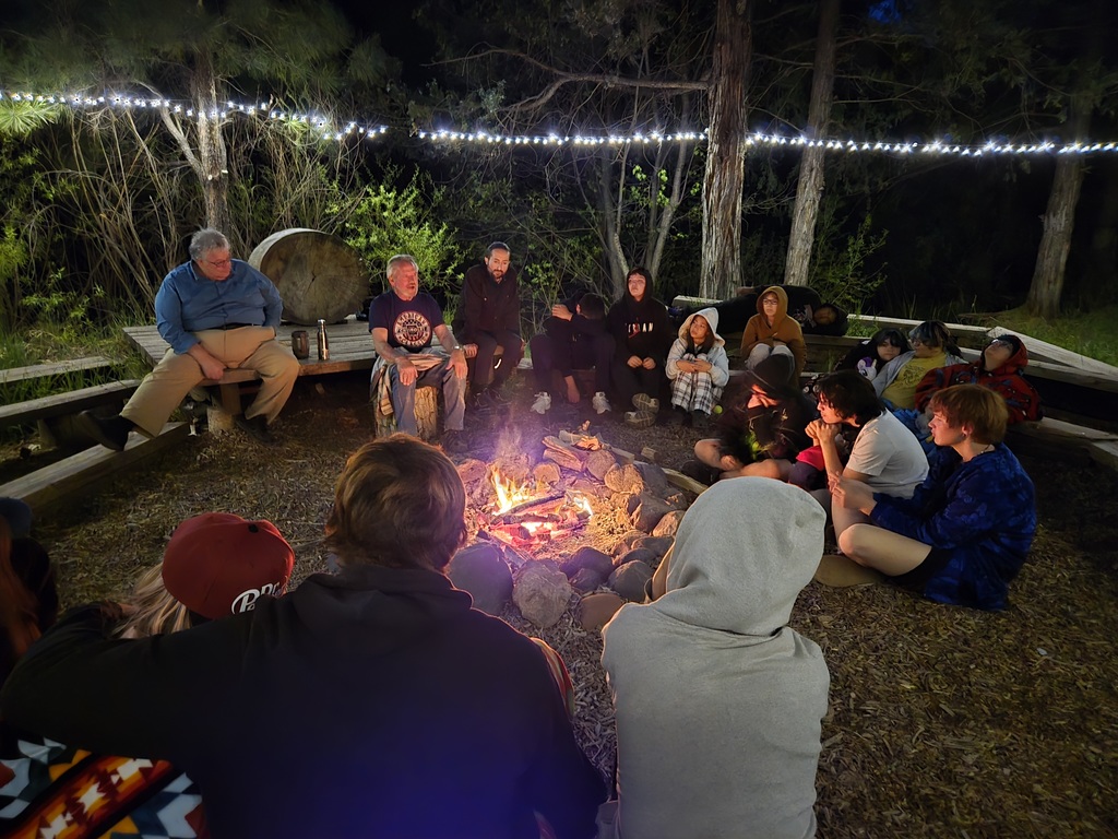students sitting around a campfire
