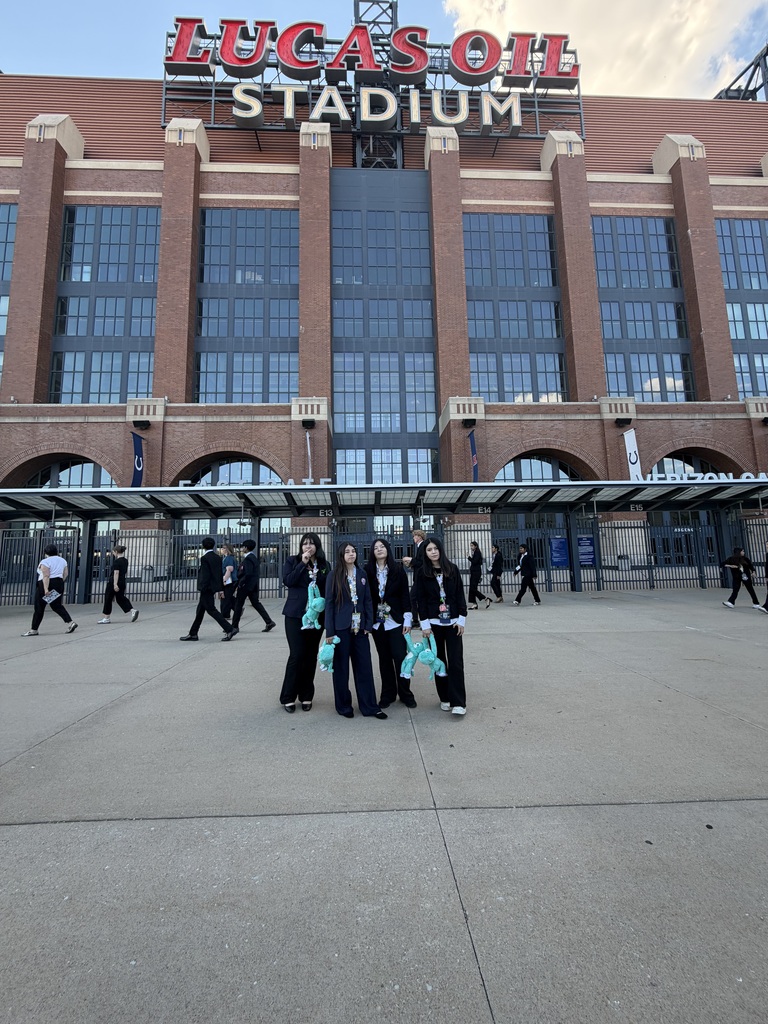students posing in front of Lucas Oil Stadium