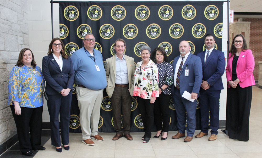 KY Secretary of State Michael Adams with district leadership team in front of CFI background